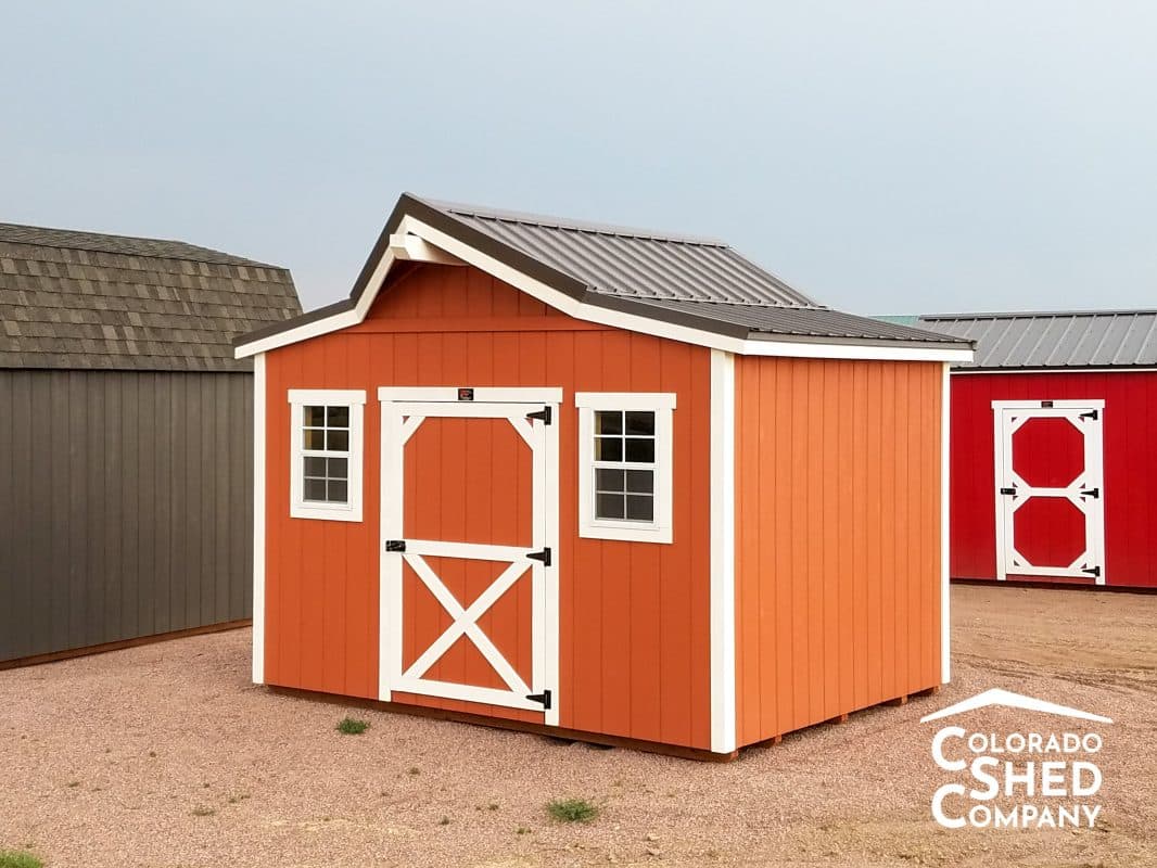 A western style storage shed with red walls and white trim.