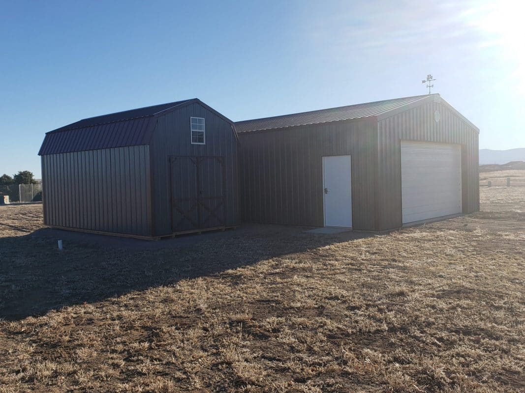 A delivered 10x20 barn style storage shed beside another building.
