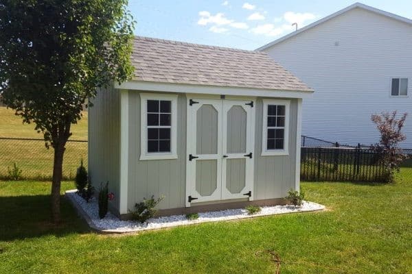 A 10x12 shed installed in a rural lawn.