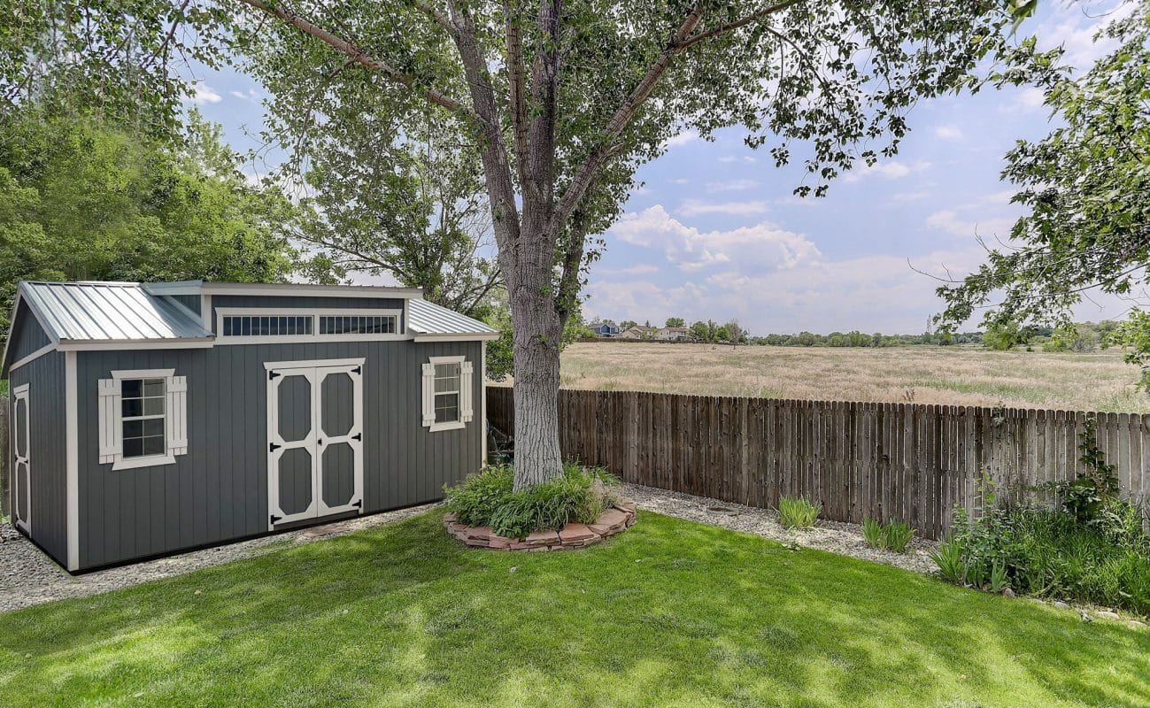 A studio gable style storage shed in a backyard.