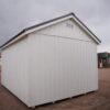The sky is dotted with clouds as a 12x16 Studio Gable storage shed stands in the foreground of the picture.