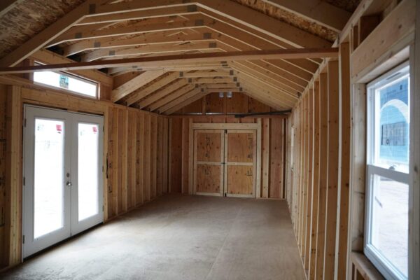 Studio Gable 12x28 storage shed viewed from the inside, showing the double swinging doors and double residential doors.