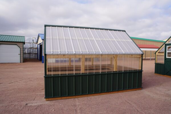 Side view of an 8x12 Green House with wood frame, green metal siding and roof, and plastic covering on the upper walls.