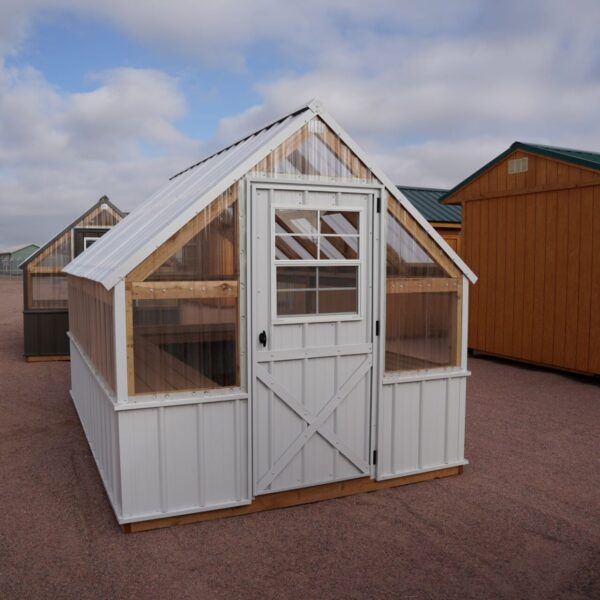 Front view of an 8x12 Green House with wood frame, metal siding and roof, and plastic covering on the upper walls.
