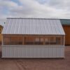 Side view of an 8x12 Green House with wood frame, metal siding and roof, and plastic covering on the upper walls.
