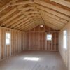 Interior view of the Gable storage shed w/ Porch 14x32 prepared for a more residential use, facing away from the entrance. The interior still has not been finished.