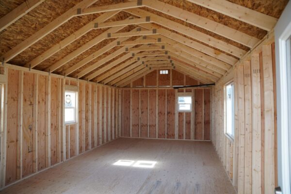 Interior view of the Gable storage shed w/ Porch 14x32 prepared for a more residential use, facing away from the entrance. The interior still has not been finished.