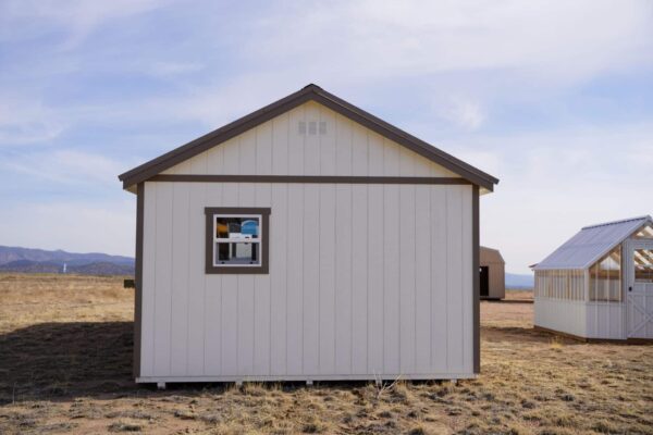 Gable storage shed w/ Porch 14x32 prepared for a more residential use, viewed from the back, highlighting one window in the back.