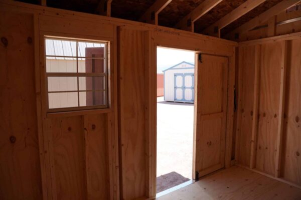 Tackroom Style 8x12 storage shed with wood siding facing out of the double doors.