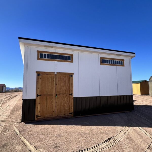 10x20 Royal Gorge Style storage shed with black metal wainscoting, white walls, wooden double doors and short wide windows at the top.