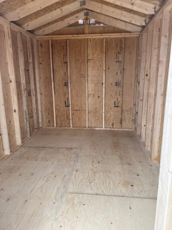 A house is being remodeled with wooden beams, hardwood planks, plywood, building insulation, doors, plaster, and a wooden ceiling.