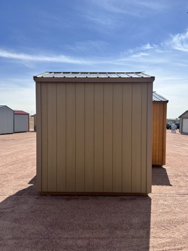 A view of the back of a beige 6x8 Gable Style storage shed with Interior Finish.