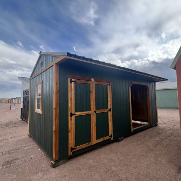 10x20 Loafing Shed with Tackroom large shed with double doors plus a large open entrance and a window. Green walls and wooden trim, metal roof.
