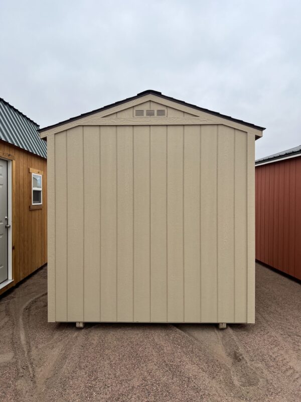 The sky is filled with clouds as a house, garage, shed, and outdoor door stand on the property.
