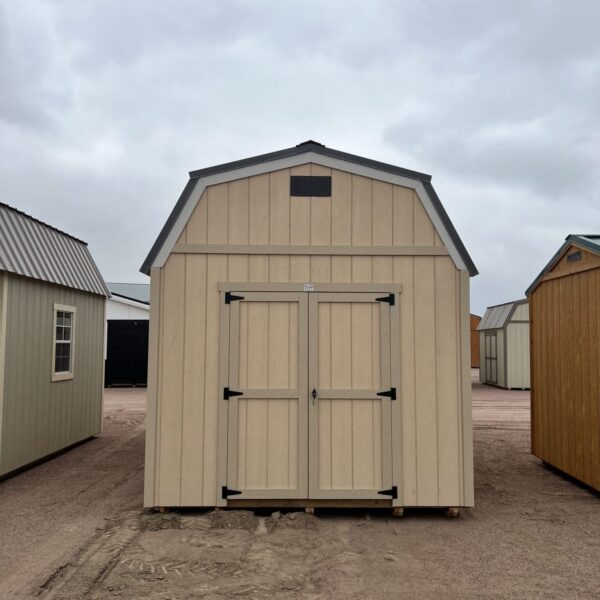 The sky is dotted with clouds as a shed and a house with a door stand on the outdoor property.