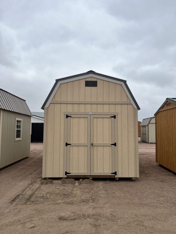 The sky is dotted with clouds as a shed and a house with a door stand on the outdoor property.