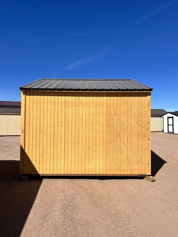 The back view of our 12x12 Loafing shed reveals a sleek dark grey roof, complementing the warm golden brown color of the shed's exterior.