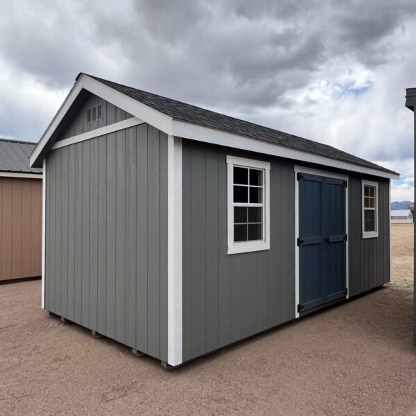 A view from the front corner of a 10x20 Gable Style storage shed with grey walls and big blue-grey swinging doors.