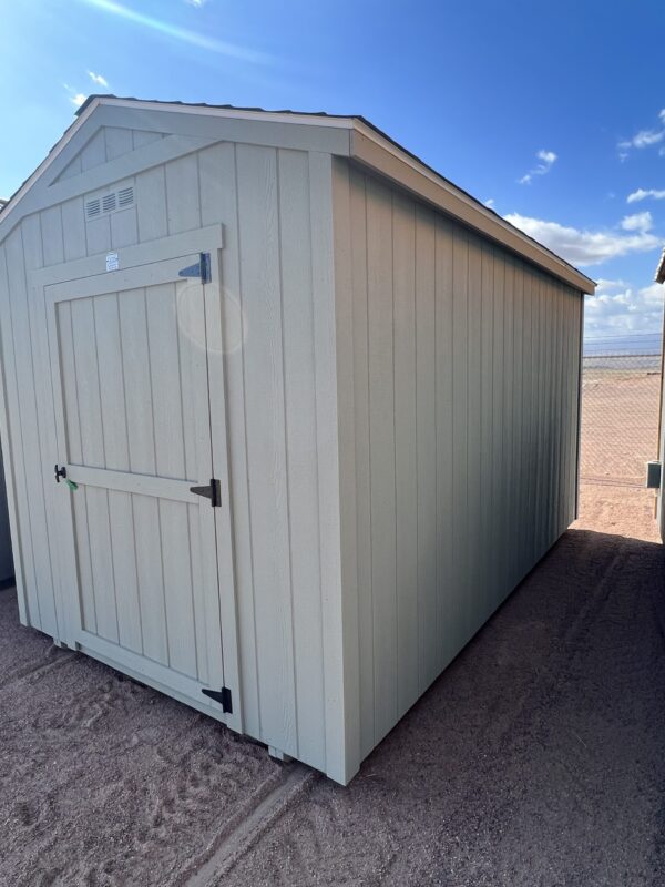 The sky is dotted with clouds as a wooden 8x14 Gable Style storage shed stands in the outdoor property.