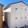 Capture the left front corner view of our 8x14 Gable Style storage shed, revealing its stylish light grey wooden paneling and sleek design. This angle showcases the shed's architectural charm and versatility, making it a functional and visually appealing addition to any outdoor space.