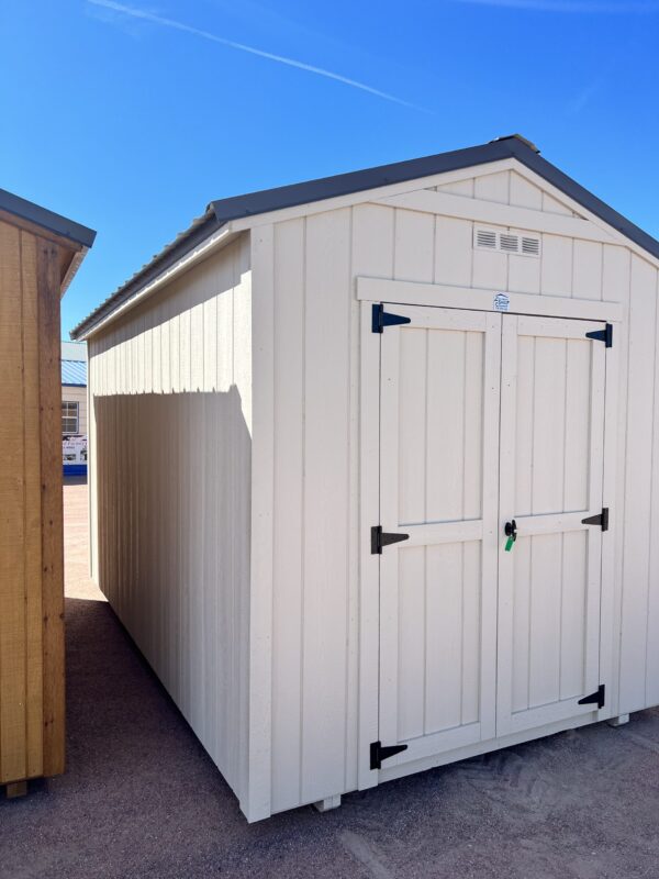 Capture the left front corner view of our 8x14 Gable Style storage shed, revealing its stylish light grey wooden paneling and sleek design. This angle showcases the shed's architectural charm and versatility, making it a functional and visually appealing addition to any outdoor space.