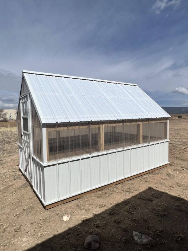 The sky is filled with fluffy clouds as a 8x12 Greenhouse stands in the foreground.