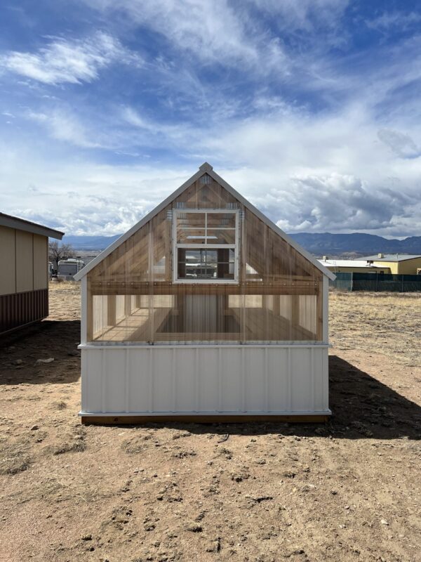 The sky is dotted with clouds as a 8x12 Greenhouse stands tall against the outdoor backdrop.