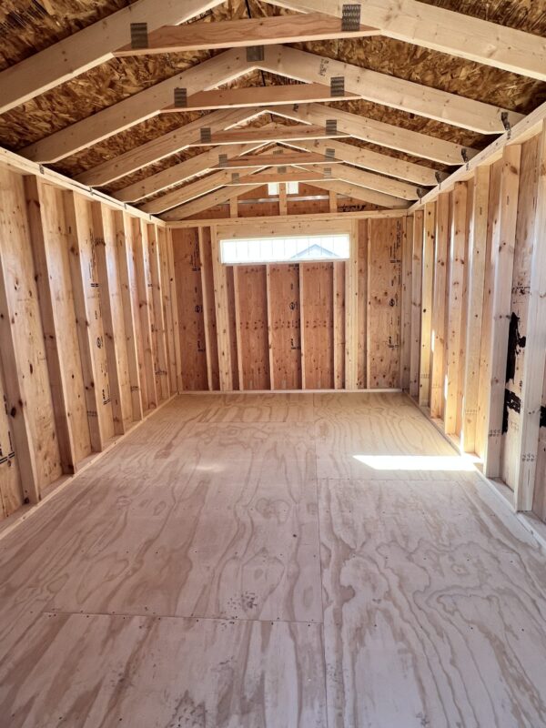 View from just inside the shed doors, offering a glimpse of the spacious interior. Step into a world of organized possibilities with this 10x16 Gable Style storage shed with ample room for your belongings.