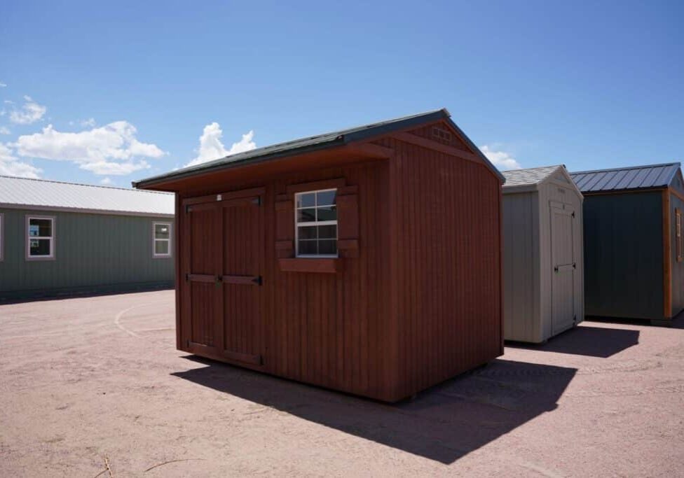 Tackroom Style 8x12 storage shed with wood siding, double doors, and a window.