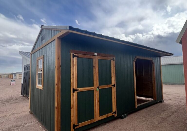 10x20 Loafing Shed with Tackroom large shed with double doors plus a large open entrance and a window. Green walls and wooden trim, metal roof.