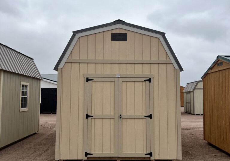 The sky is dotted with clouds as a shed and a house with a door stand on the outdoor property.