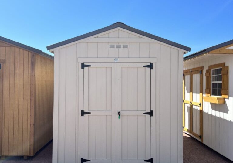 Take in the front view of our 8x14 Gable Style storage shed, revealing its stylish design and attention to detail. The light grey wooden paneling enhances the shed's aesthetic appeal, while the symmetrical lines and proportions create a balanced and pleasing visual impact. This practical storage solution is as visually appealing as it is functional, making it a standout addition to your property.
